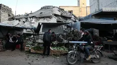 Warga Suriah membeli produk makanan di pasar menjelang buka puasa pada hari kedua bulan suci Ramadhan, di kota Ariha yang dilanda perang, di provinsi Idlib, Kamis (15/4/2021). Mereka menjalankan Ramadhan di antara lautan reruntuhan bekas konflik gencatan senjata. (Omar HAJ KADOUR/AFP)