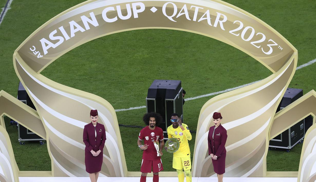 Meshaal Barsham (kanan) dan Akram Afif berfoto bersama saat mendapatkan pengharagaan kiper terbaik dan pemain terbaik Piala Asia 2023 di Lusail Stadium, Doha, Qatar, Sabtu (10/02/2024). (AP Photo/Hussein Sayed)
