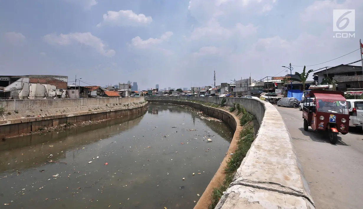 Angkutan odong-odong melintasi pinggir Kali Ciliwung yang tengah dipenuhi sampah, Jakarta, Selasa (4/9). Sampah yang mencemari Kali Ciliwung terjadi dari hulu hingga hilir. (Merdeka.com/Iqbal Nugroho)