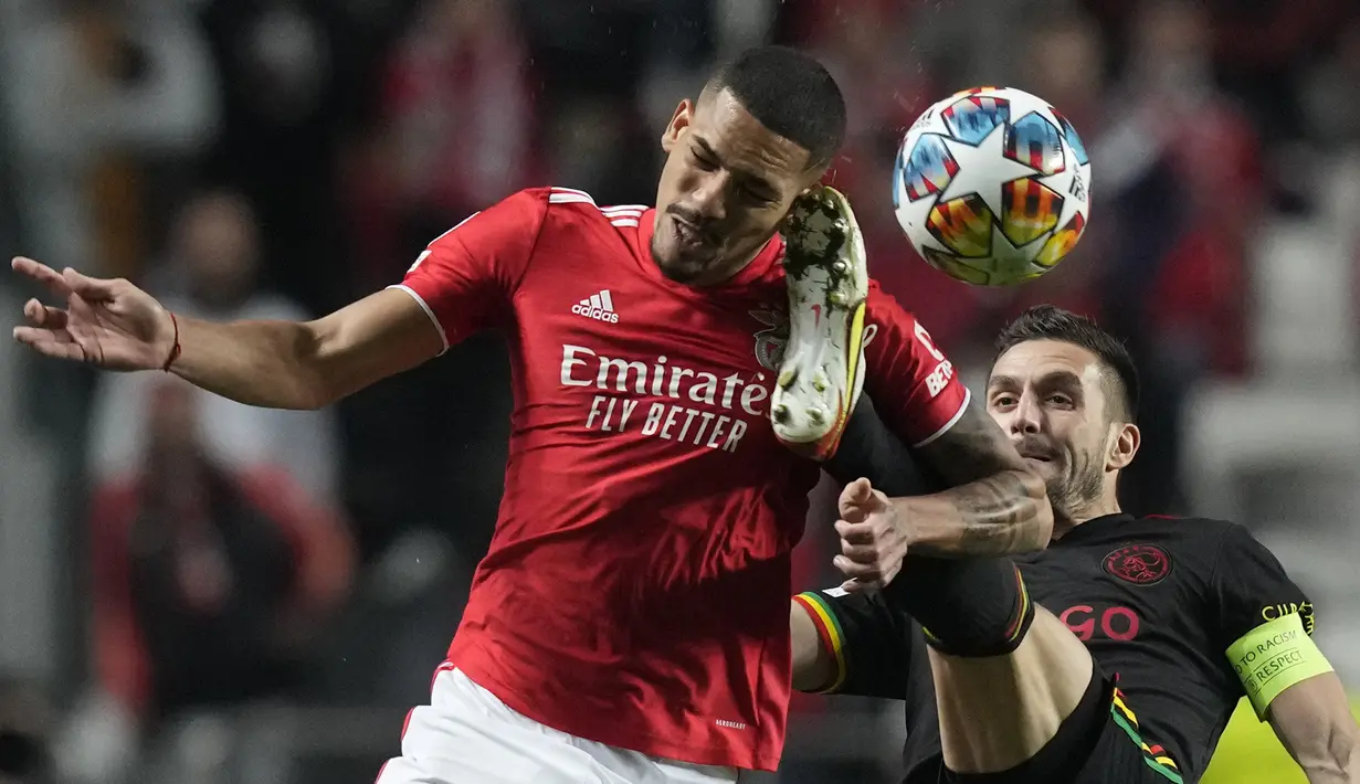 Bek Benfica, Gilberto (kiri) berebut bola dengan gelandang Ajax, Dusan Tadic pada pertandingan leg pertama babak 16 Liga Champions di Stadion Da Luz, Lisbon, Kamis (24/2/2022). Benfica bermain imbang atas Ajax 1-1.  (AP Photo/Armando Franca)