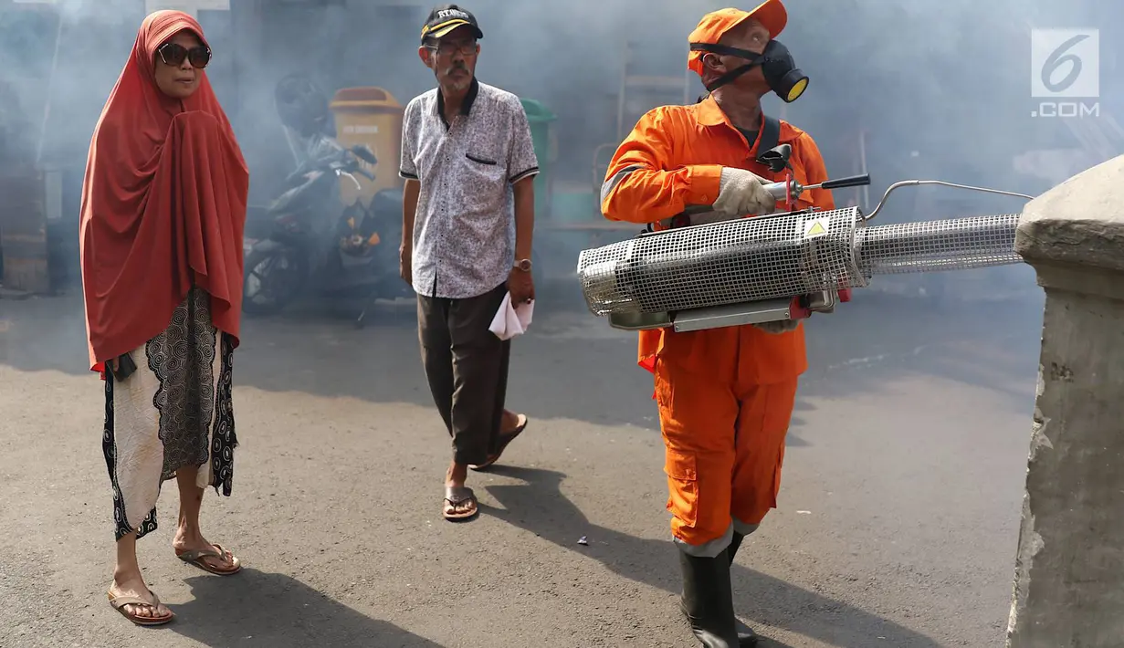 Warga melihat saat petugas melakukan pengasapan (fogging) di sebuah sekolah di kawasan Kebon Baru, Tebet, Jakarta, Kamis (28/2). Pengasapan dilakukan terkait adanya warga di kawasan itu yang terkena penyakit demam berdarah (Liputan6.com/Immanuel Antonius)
