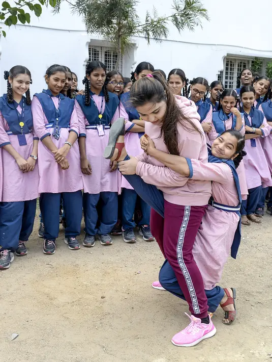 Juara karate internasional Muslim India, Syeda Falak menunjukkan teknik bela diri kepada seorang siswi di Telangana Minorities Residential Girls School di Hyderabad, India (17/6). (AFP Photo/Noah Seelam)