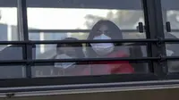 Dua wanita India mengenakan masker berada di dalam bus saat keluar dari Bandara Internasional Indira Gandhi setelah dievakuasi dari kota Wuhan di China, di New Delhi (1/2/2020). Jumlah total kematian akibat wabah virus corona di China tercatat mencapai 259 hingga Jumat (31/1/2020). (AFP/Money Sharma