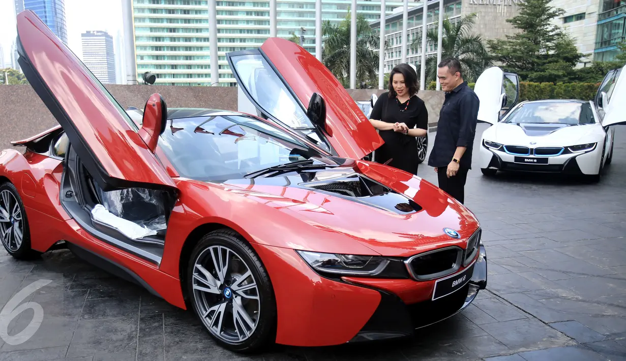 President Director of BMW Group Indonesia Karen Lim (kiri) berbincang dengan pembeli pertama unit mobil hybrid BMW i8 Protonic Red Edition, Sonny Kastara usai penyerahan mobil tersebut di Jakarta, Kamis (20/4).(Liputan6.com/Angga Yuniar)