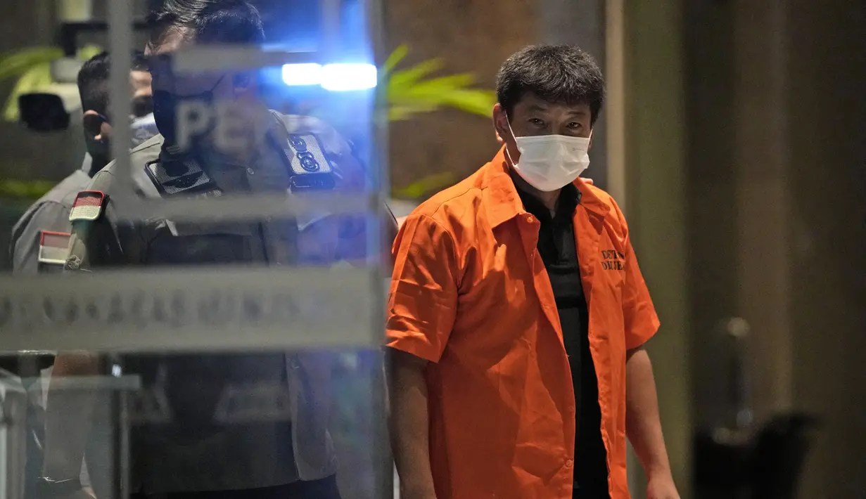 Petugas Imigrasi Indonesia mengawal buronan Jepang Mitsuhiro Taniguchi yang ditangkap di pulau Sumatera pada awal Juni, sebelum dideportasi di Jakarta, Rabu (22/6/2022). Mitsuhiro yang berusia 48 tahun dan merupakan warga negara Jepang dideportasi karena paspor kebangsaannya telah dicabut oleh Kedutaan Jepang dan tidak memiliki izin tinggal. (AP Photo/Dita Alangkara)