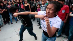 Anak perempuan juga mengikuti adu pukul dalam Tradisi Xochimilcas di Zitlala, Guerrero, Meksiko (18/2). Menurut kepercayaan warga pribumi (Suku Aztec) tradisi ini sebagai simbol perlindungan terhadap kaum lemah & perempuan. (AFP PHOTO/Pedro Pardo)