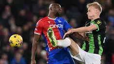 Striker Crystal Palace #14 Jean-Philippe Mateta (kiri) dan bek Brighton and Hove Albion #29 Jan Paul van Hecke berebut bola di udara pada laga pekan ke-18 Premier League di Selhurst Park, Jumat (22/12/2023) dini hari WIB. (Glyn KIRK / AFP)