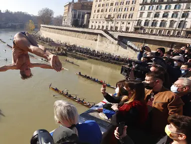 Marco Fois dari Italia melompat ke Sungai Tiber dari Jembatan Cavour setinggi 18 meter (59 kaki) untuk merayakan Tahun Baru di Roma, 1 Januari 2022. (AP Photo/Riccardo De Luca)