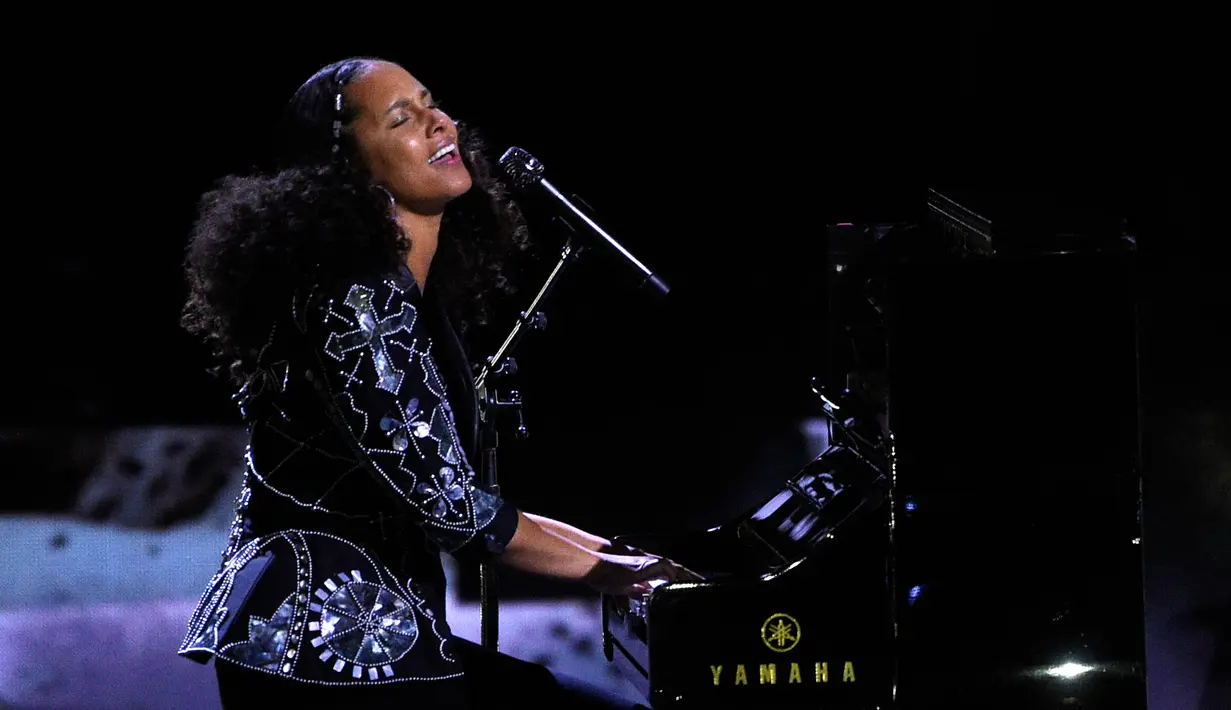 Aksi Alicia Keys memainkan piano saat membawakan lagu dalam acara WE Day California di Inglewood, California, AS (27/4). Penyanyi 36 tahun ini memutuskan tidak mengenakan make up sejak penampilannya di MTV VMA 2016. (AP Photo/Chris Pizzello)