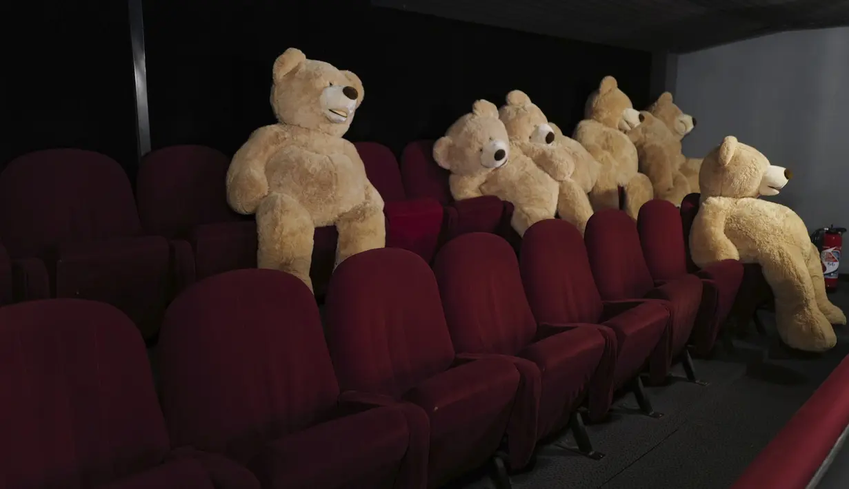 Boneka Teddy Bear, yang disiapkan oleh Philippe Labourel, diletakkan di bioskop Les Ursulines hari pertama pembukaan kembali di Paris, Rabu (19/5/2021). Boneka-boneka beruang tersebut didedikasikan bagi anak-anak untuk mengingatkan aturan jarak sosial. (AP Photo/Francois Mori)