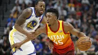 Aksi pemain Utah Jazz, Donovan Mitchell (kanan) mencoba melewati adangan pemain Warriors, Andre Iguodala pada lanjutan NBA basketball game di Vivint Smart Home Arena, Salt Lake City, (30/1/2018). Utah menang 129-99. (AP/Rick Bowmer)