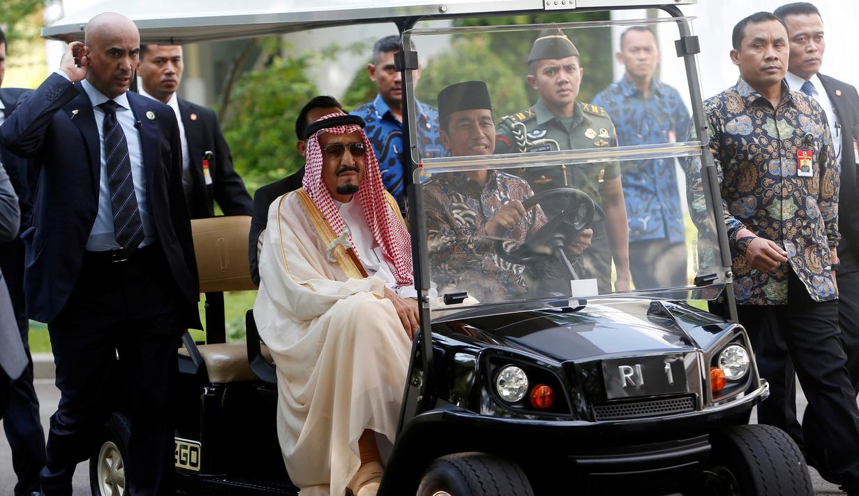 Sejumlah pengawal Raja Salman terlihat menjaga ketat mobil yang dikemudikan Jokowi saat keliling halaman Istana Merdeka, Jakarta, Kamis (2/3). (AFP Photo/ Pool/ ADI WEDA)