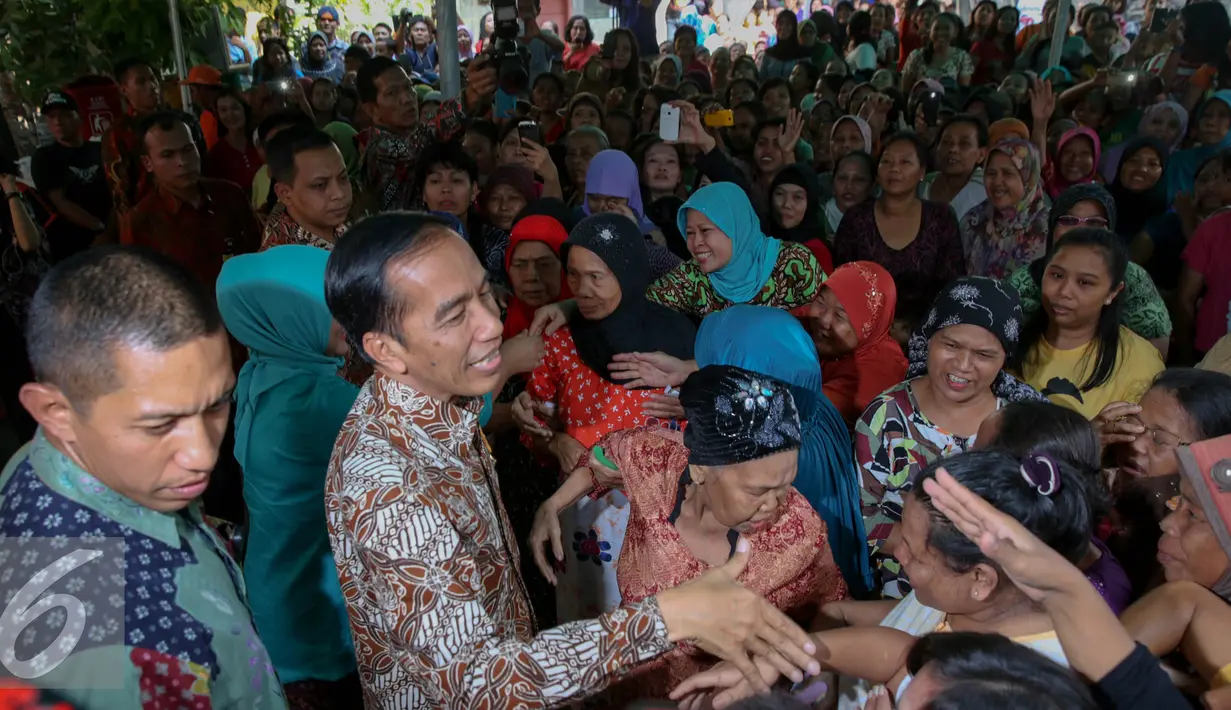 Presiden Joko Widodo didampingi Ibu Negara Iriana disambut warga saat blusukan ke Kedoya dan Petamburan, Jakarta, Selasa (1/9/2015). Selain sembako, Presiden Jokowi juga membagikan buku dan baju kepada anak-anak. (Liputan6.com/Faizal Fanani)