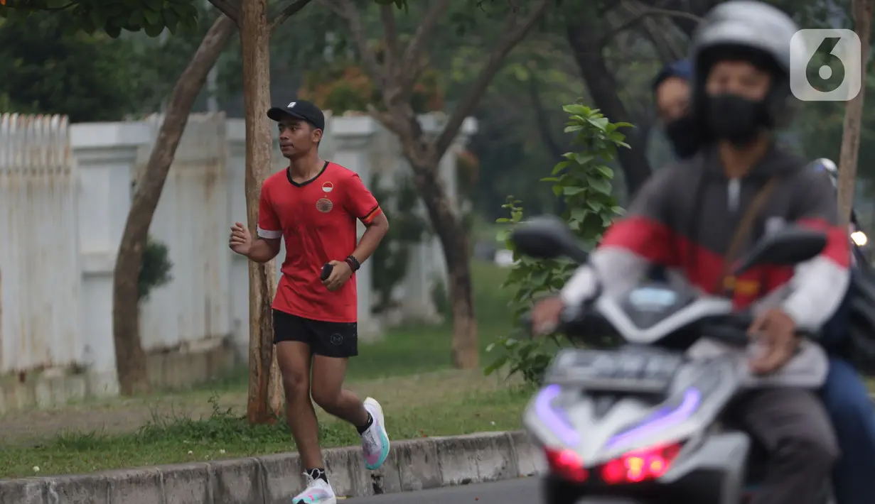 Warga berlari di area lingkar luar kawasan Stadion Pakansari, Kabupaten Bogor, Sabtu (11/9/2021). Kawasan ini kembali ramai dengan aktivitas warga seiring penurunan level PPKM di wilayah Jabodetabek. (Liputan6.com/Helmi Fithriansyah)