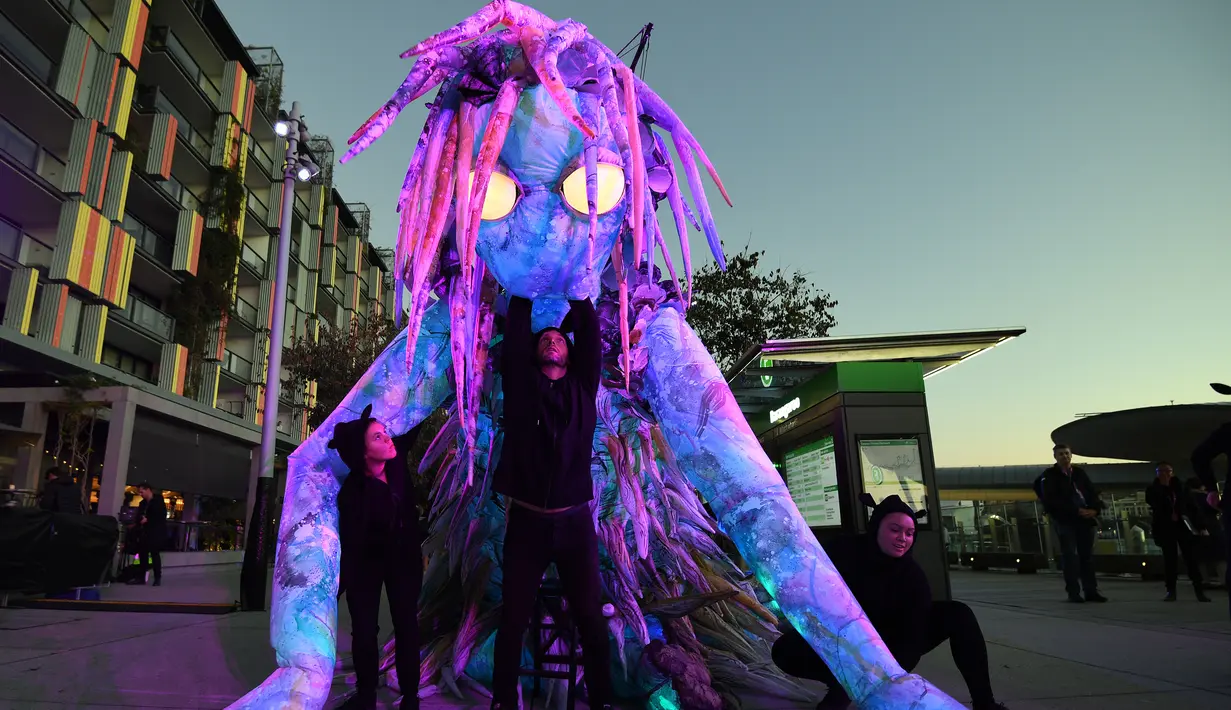 Pemain menunjukkan makhluk misterius setinggi enam meter berhias cahaya saat pratinjau Festival Vivid Sydney di Barangaroo, Sydney, Australia, Rabu (23/5). Festival Vivid Sydney berlangsung pada 25 Mei hingga 16 Juni 2018. (Saeed KHAN/AFP)
