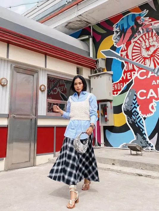 Ingin berkreasi dengan kemeja suami? Coba tambahkan knit tank top sebagai outer seperti yang dikenakan Ayla Dimitri satu ini. Agar look makin feminine, kenakan plaid skirt dan heels. (Instagram/ayladimitri).