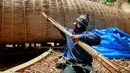 Salah satu pekerja mengikat batang pohon Totora yang akan digunakan untuk membuat perahu 'Viracocha III' di kota La Paz Bolivia, Rabu (19/10). Tumbuhan Totora atau alang-alang mengambang ini banyak ditemukan di danau Titicaca. (Reuters/David Mercado)