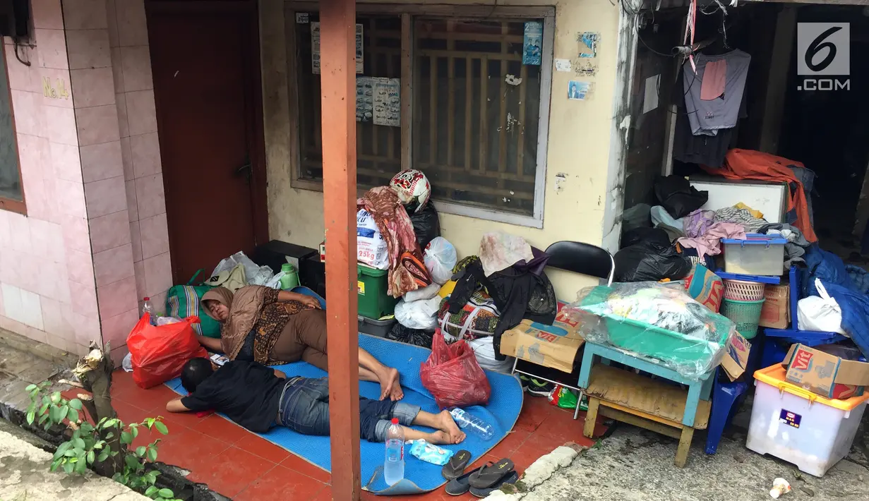 Seorang ibu tertidur pulas saat mengungsi di kolong Flyover Rawajati, Jakarta, Selasa (6/2). Ancaman banjir susulan membuat mereka takut pulang ke rumah. (Liputan6.com/Immanuel Antonius)