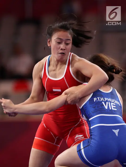Pegulat Indonesia, Ulfah Dewi (kiri) bertarung dengan pegulat Vietnam, Pham Thi Ha Phuong pada babak perdelapan final Freestyle 53 kg putri dalam Asian Games 2018 di JCC Senayan, Senin (20/8). Ulfah Dewi kalah dengan skor 3-5. (Liputan6.com/Fery Pradolo)