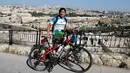Pria Taiwan, Jacky Chen, berpose dengan sepedanya di Bukit Zaitun yang menghadap ke Kota Tua Yerusalem dan Kubah Batu pada 10 Juni 2019. Pria 40 tahun itu berharap bisa menjelajahi 100 negara dengan jarak 100.000 km sebelum mengakhiri petualangannya 3 tahun mendatang. (MENAHEM KAHANA/AFP)