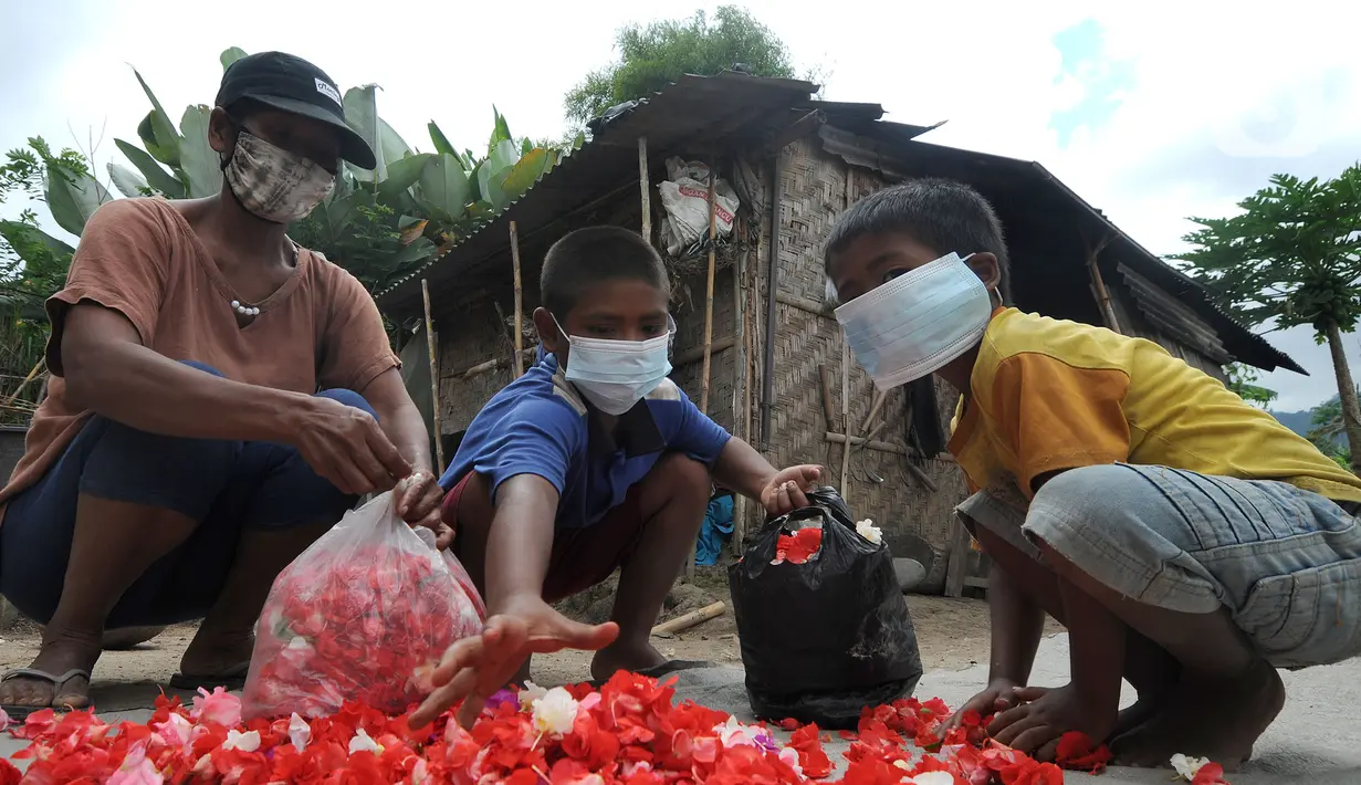 Seorang ibu ditemani dua anaknya memanen bunga pacar air di kawasan Sidemen, Karangasem, Bali, Kamis (2/9/2021). Jumlah penduduk miskin di Bali bertambah sekitar 5.050 orang dibandingkan pada September 2020 yang mencapai 196.920 orang. (merdeka.com/Arie Basuki)