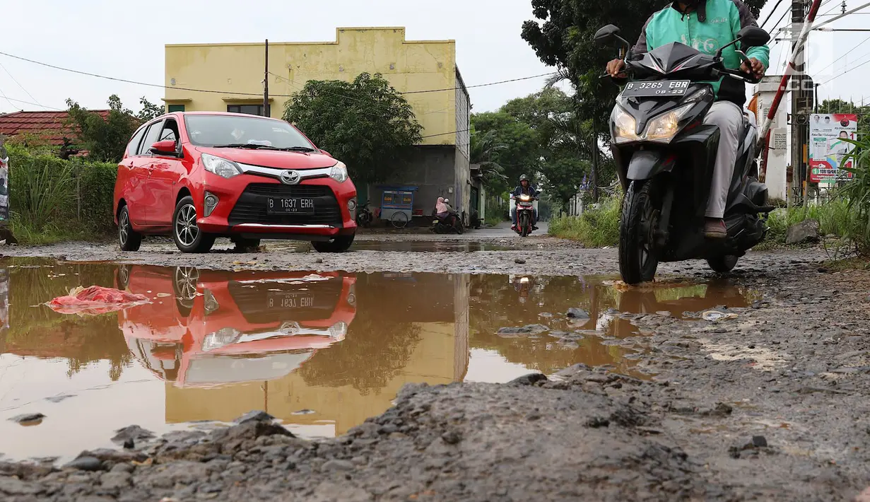 Kendaraan menghindari kubangan pada jalan yang rusak di Jalan Pertamina, Kemiri Muka, Depok, Jawa Barat, Selasa (5/3). Jalan rusak yang telah berlangsung bertahun-tahun tersebut tak kunjung diperbaiki. (Liputan6.com/Immanuel Antonius)