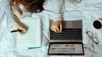 Ilustrasi menulis, teks argumentasi. (Foto oleh Ketut Subiyanto: https://www.pexels.com/id-id/foto/laptop-buku-catatan-perempuan-tempat-tidur-4132345/)