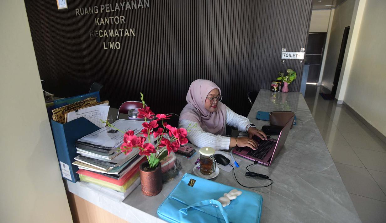 Pegawai bekerja di depan komputer dengan beberapa meja kursi yang kosong saat penerapan Work From Home (WFH) bagi aparatur sipil negara (ASN) di kantor Kecamatan Limo, Depok, Jawa Barat, Jumat (10/4/2026). Pemerintah resmi memberlakukan kebijakan work from home (WFH) bagi Aparatur Sipil Negara (ASN) selama satu hari dalam sepekan. (merdeka.com/Arie Basuki)