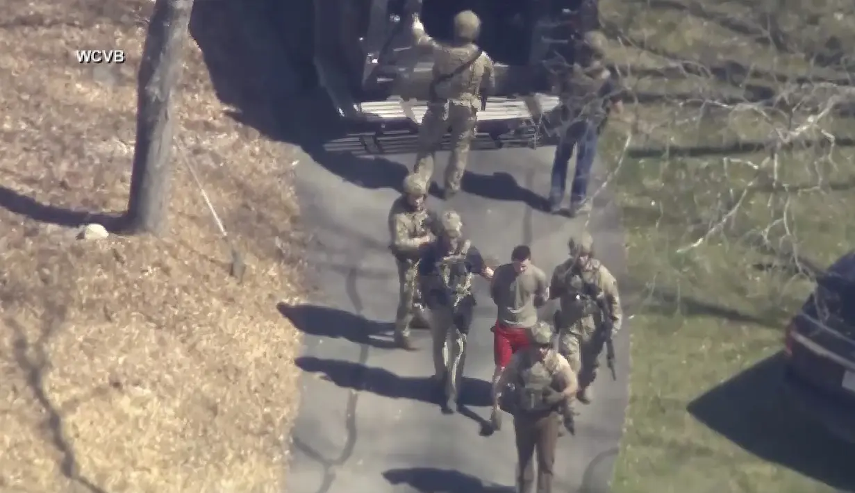 Dalam video penangkapan yang beredar, Teixeira tampak berjalan mundur ke arah petugas FBI dengan tangat terangkat, sebelum dia diborgol dan dibawa ke sebuah mobil. (WCVB-TV via AP)