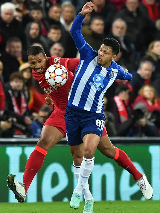 Bek Liverpool Joel Matip (kiri) bersaing dengan striker FC Porto, Evanilson pada pertandingan kelima Grup B Liga Champions di Anfield, Kamis (25/11/2021) dini hari WIB. Kemenangan Liverpool 2-0 atas sang tamu FC Porto dipersembahkan oleh gol Thiago Alcantara dan Mohamed Salah. (Anthony Devlin/AFP)