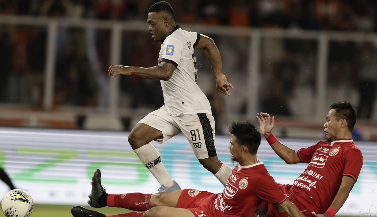 Gelandang Madura United, David Laly, berebut bola dengan pemain Persija Jakarta pada laga Shopee Liga 1 di SUGBK, Jakarta, Jumat (13/12). Persija menang 4-0 atas Madura. (Bola.com/Yoppy Renato)