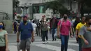 Orang-orang berjalan di alun-alun Carioca pada hari pertama pencabutan aturan wajib masker di luar ruangan, di Rio de Janeiro, Brasil, Kamis (28/12/2021). Pencabutan aturan wajib masker ini efektif berlaku pada Kamis (28/10) waktu setempat. (MAURO PIMENTEL / AFP)