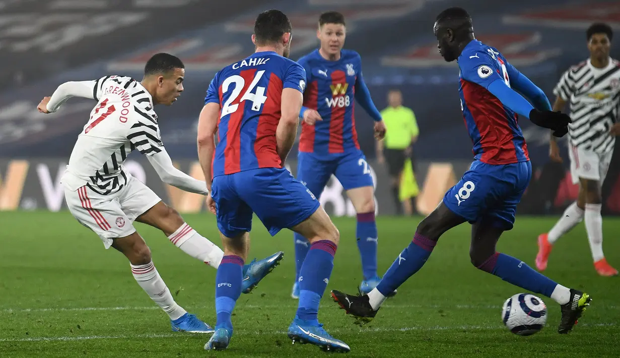 Striker Manchester United, Mason Greenwood (kiri) melepakan tendangan yang berhasil diblok pemain Crystal Palace dalam laga lanjutan Liga Inggris 2020/21 pekan ke-27 di Selhurst Park, Rabu (3/3/202). Manchester United bermain imbang 0-0 dengan Crystal Palace. (AFP/Mike Hewitt/Pool)