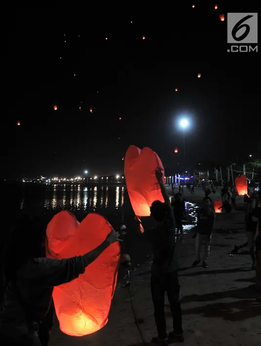Pengunjung menerbangkan lampion saat perayaan Tahun Baru Imlek di Pantai Lagoon, Ancol, Jakarta, Selasa (5/2) malam. Sebanyak 500 lampion diterbangkan oleh pengunjung dalam  rangka menutup Festival Imlek di Ancol. (Merdeka.com/Iqbal S Nugroho)