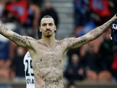 Penyerang Paris Saint-Germain Zlatan Ibrahimovic merayakan selebrasi pamer tato saat timnya bermain imbang 2-2 dengan Caen pada 14 Februari 2015. (AFP Photo/Kenzo Tribouillard)