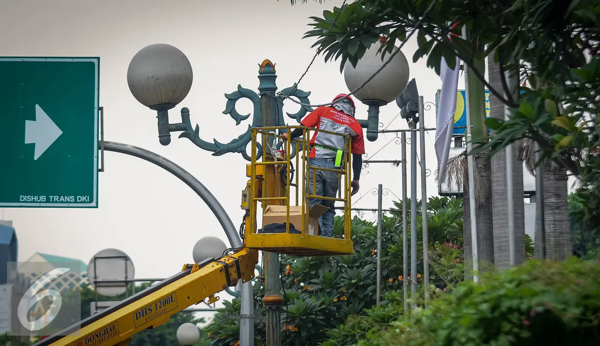 Petugas Suku Dinas Penerangan Jalan Umum (PJU) melakukan perawatan lampu jalanan di Kawasan KH Wahid Hasyim, Jakarta, Selasa (27/9). Perawatan rutin dilakukan untuk memastikan penerangan untuk jalan tetap berfungsi. (Liputan6.com/Faizal Fanani)