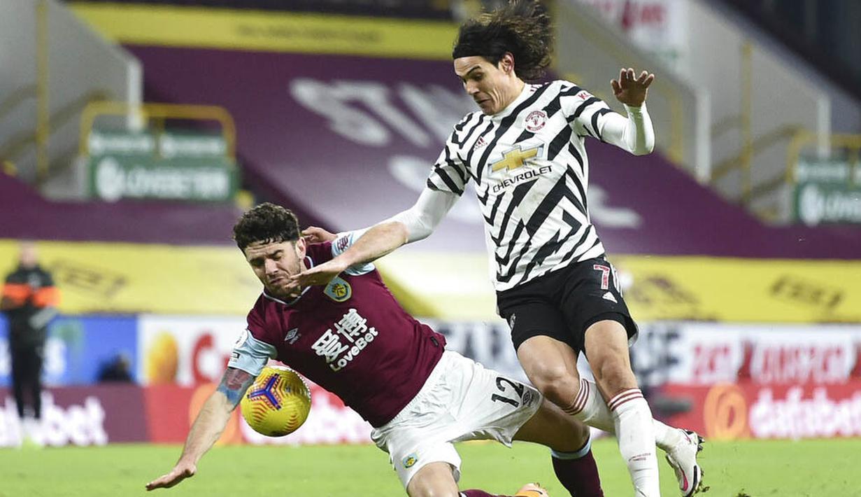 Striker Manchester United, Edinson Cavani, berebut bola dengan pemain Burnley, Robbie Brady, pada laga Liga Inggris di Stadion Turf Moor, Rabu (13/1/2021). Setan Merah menang dengan skor 1-0. (Peter Powell/Pool via AP)