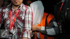 Bupati Klaten Sri Hartini menutupi wajahnya usai di periksa Komisi Pemberantasan Korupsi (KPK), Jakarta, Sabtu (31/12). Komisi Pemberantasan Korupsi menetapkan Bupati Klaten Sri Hartini (SHT) sebagai tersangka kasus suap. (Liputan6.com/Helmi Affandi)