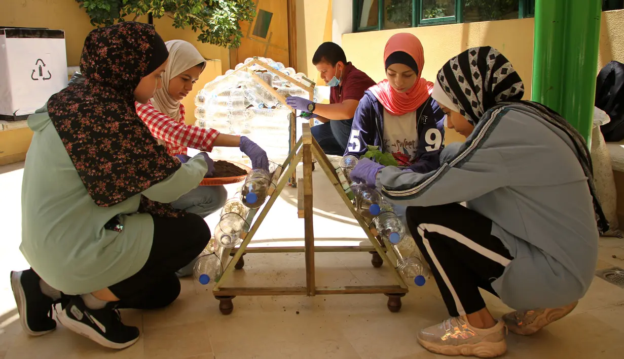 Anak-anak Palestina meletakkan tanaman ke dalam botol plastik di Pusat Anak-Anak Al-Qattan, Gaza City, Senin (20/7/2020). Program ini bernama daur ulang limbah rumah tangga menjadi produk yang ramah lingkungan. (Xinhua/Rizek Abdeljawad)