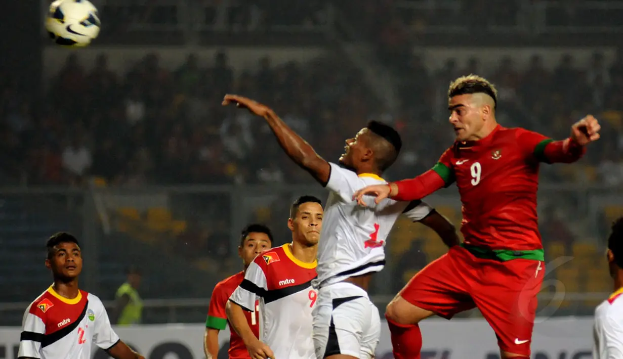 Pemain depan Timnas Indonesia, Cristian Gonzales (kanan) menyundul bola saat berlaga melawan Timor Leste di Stadion GBK Jakarta, Selasa (11/11/2014). Indonesia unggul 4-0 atas Timor Leste. (Liputan6.com/Helmi Fithriansyah)