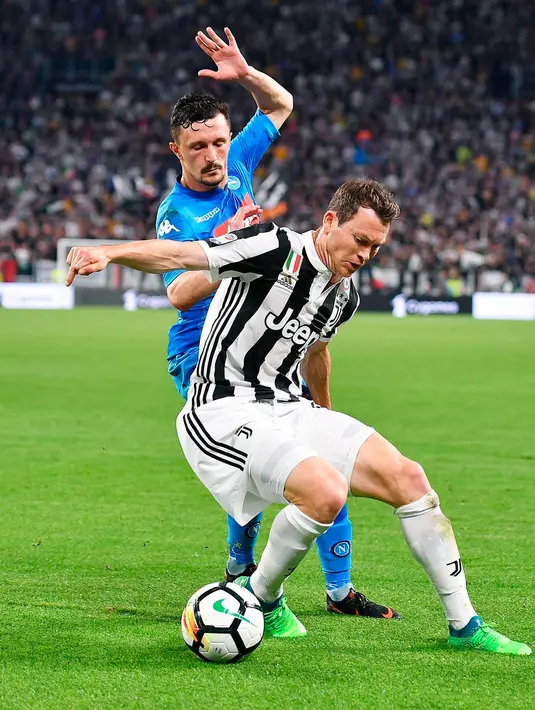 Bek Juventus, Stephan Lichtsteiner berusaha mengontrol bola dari kejaran pemain Napoli, Mario Rui saat bertanding pada lanjutan Liga Serie A Italia di Stadion Allianz di Turin (22/4). Juventus takluk atas Napoli 1-0. (AP Photo/Alessandro Di Marco)