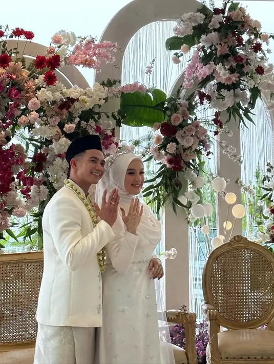 Kedua pengantin tampak begitu bahagia di hari pernikahannya. Keduanya mengenakan pakaian pengantin warna putih. [Instagram/fahiramira]