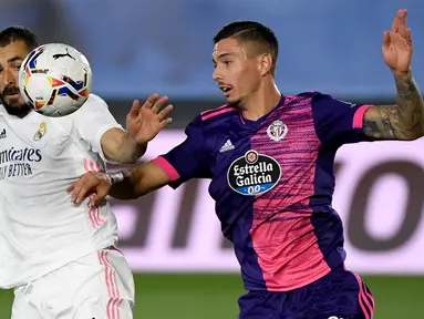 Bek Valladolid, Javi Sanchez (kanan) berebut bola dengan pemain depan Real Madrid, Karim Benzema pada lanjutan La Liga Spanyol di stadion Alfredo, Rau (30/9/2020). Real Madrid menekuk Real Valladolid denga skor 1-0. (PIERRE-PHILIPPE MARCOU / AFP)