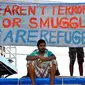 Seorang imigran Sri Lanka duduk di bawah spanduk yang menyatakan mereka pengungsi dan bukan teroris atau korban penyelundupan manusia di Tanjungpinang, Kepri. (Antara).