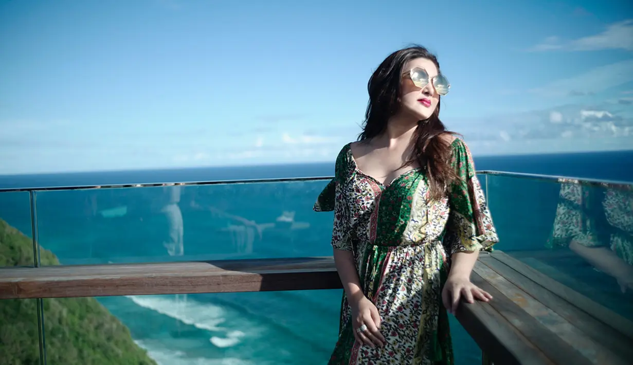 Berlatar belakang indahnya pantai berwarna biru, Ashanty tampil dengan gaya yang simpel. Dirinya hanya mengenakan long dress motif foloral. Sangat menyantu dengan alam sekali, bukan? (Liputan6.com/IG/ashanty_ash)