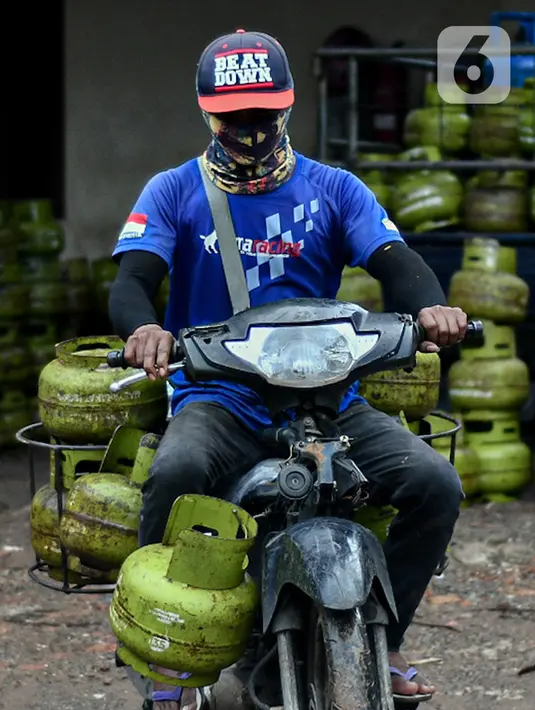 Pekerja membawa tabung LPG 3 kg di agen LPG kawasan Cibubur, Jakarta, Jumat (26/2/2021). Berdasarkan data Kementerian ESDM, volume LPG 3 kg tahun ini diperkirakan mencapai 6,89 juta metrik ton. (Liputan6.com/Herman Zakharia)