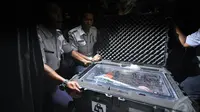 Petugas menunjukan kotak berisi bagian dari 'black box' yang merupakan FDR sesaat setelah kotak tersebut tiba di kantor KNKT, Jakarta, Senin (12/1/2015). (Liputan6.com/Miftahul Hayat) 