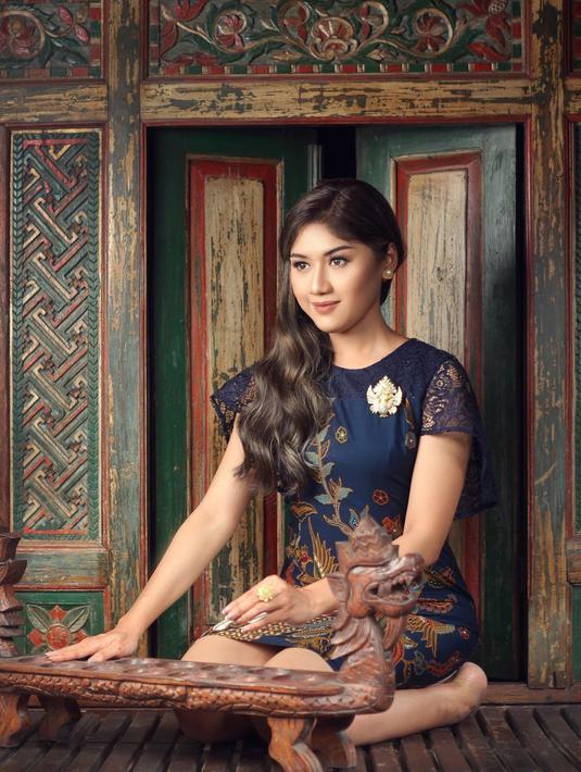 Foto lain menampilkan Erina Gudono dalam balutan gaun rilisan Rianty Batik berwarna dasar hitam dengan lengan pendek dari brokat. Ia duduk berkawan mainan tradisional dakon. Erina Gudono membuat netizen jatuh hati berkat riasan wajah natural dari Maura Pavita. Ia membiarkan rambutnya tergerai di sisi kanan. Tata rambut ini dikerjakan Arya Kusuma. (Foto: Dok. Instagram @arifinphotos)