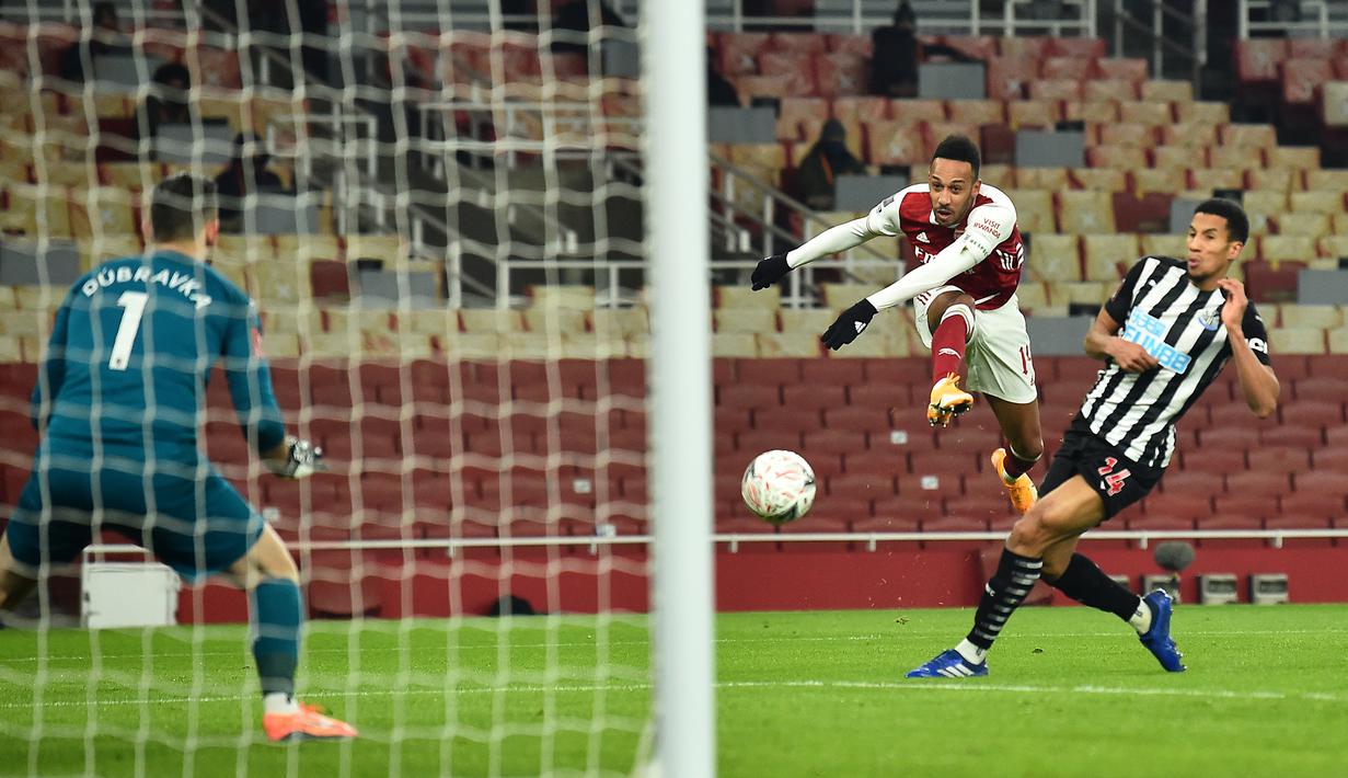 Striker Arsenal, Pierre-Emerick Aubameyang (tengah) melepaskan tendangan ke gawang Newcastle United dalam laga babak ke-3 Piala FA 2020/21 di Emirates Stadium, Sabtu (9/1/2021). Arsenal menang 2-0 atas Newcastle United melalui extra time. (AFP/Glyn Kirk/Pool)