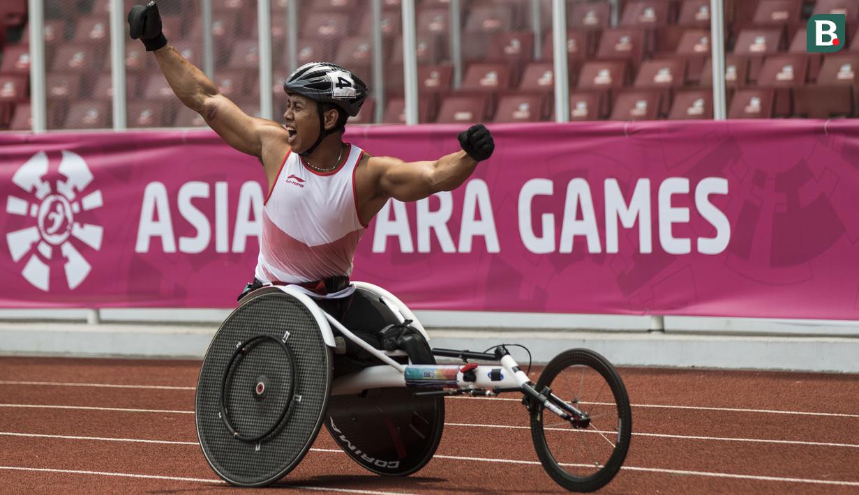Pebalap kursi roda Indonesia, Jaenal Aripin, melakukan selebrasi usai meraih medali perak pada Asian Para Games cabang atletik nomor balap kursi roda 200 meter T 54 di SUGBK, Jakarta, Jumat (12/10). (Bola.com/Vitalis Yogi Trisna)